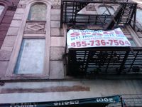One of the buildings on East 116th Street between Lexingon and Park where the first floor is rented but the several former residential apartment floors are boarded up.